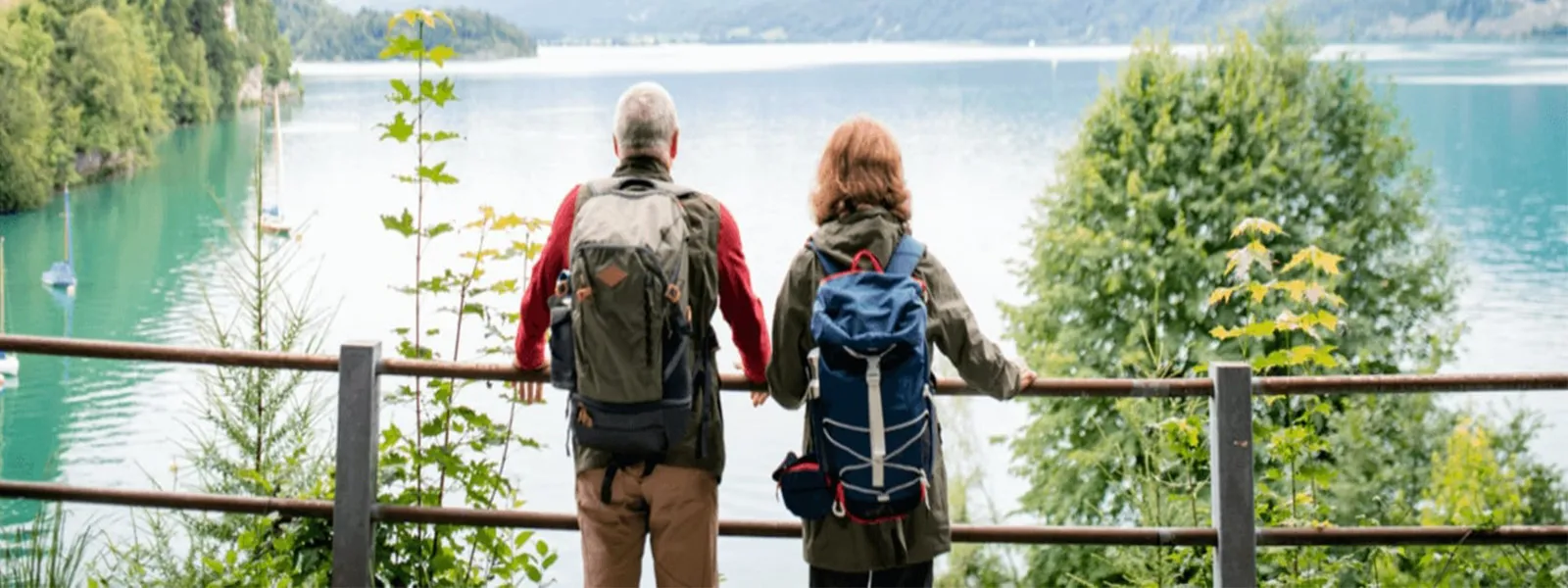 Senior couple standing by lake.