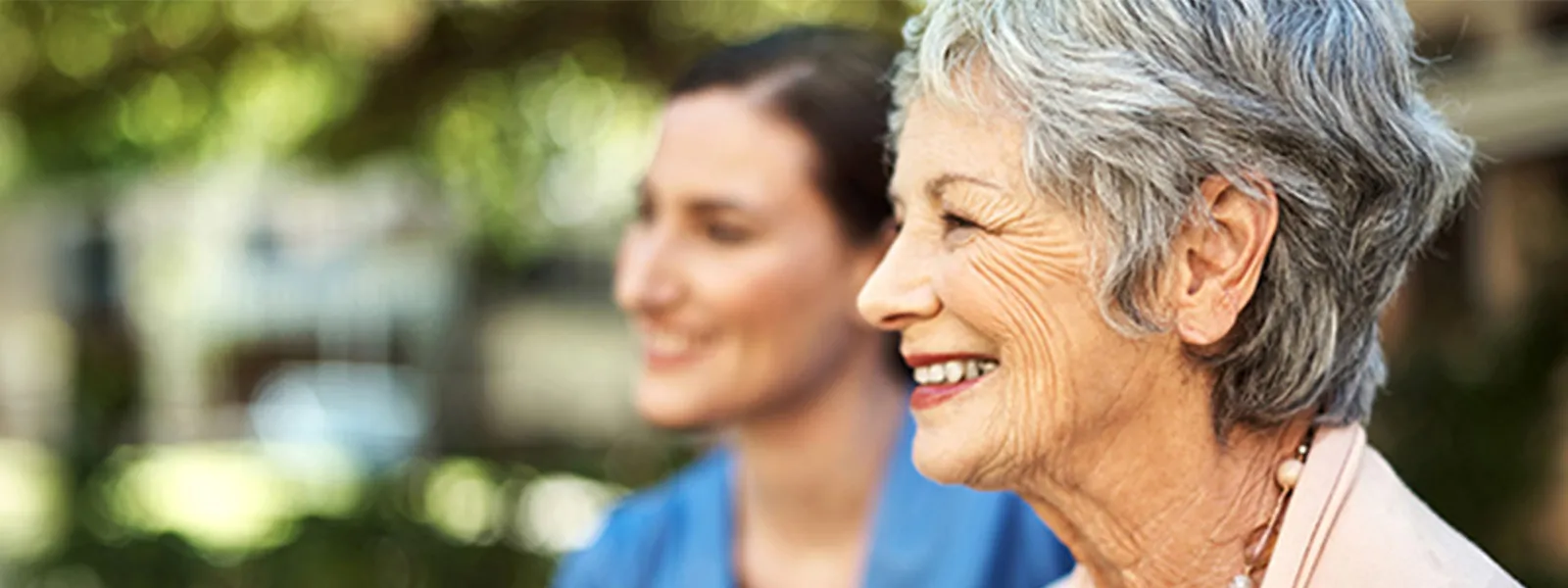 Senior woman smiling with a young nurse.