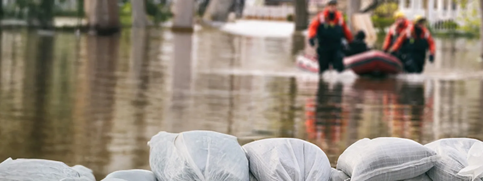 Flood Protection Sandbags with flooded homes in the background.