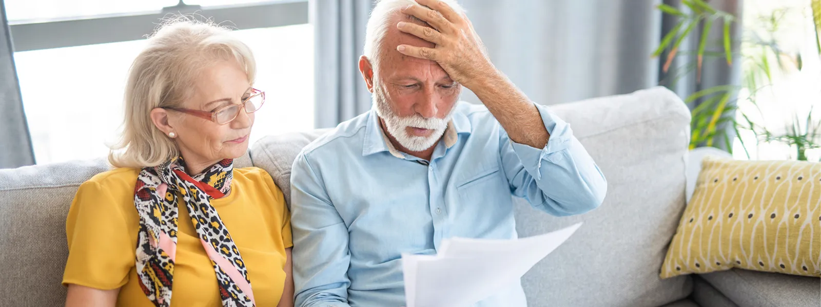 worried senior couple looking at documents