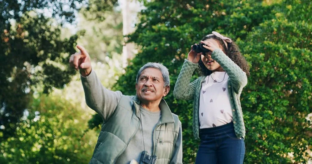 A grandfather looks at old photos with his grandson. It's never too soon to think about what to do when a loved one dies.