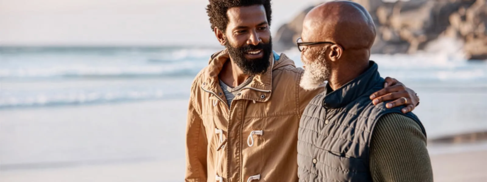 Older son and father talking a walk on the beach