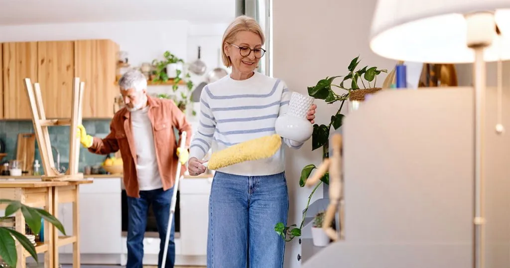 A retired couple cleaning their kitchen.