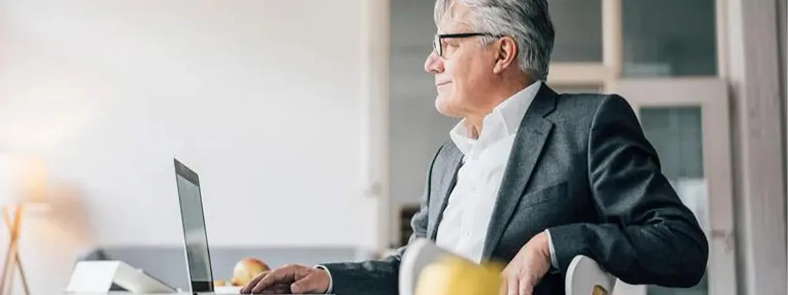 A man using his laptop at the dining table.
