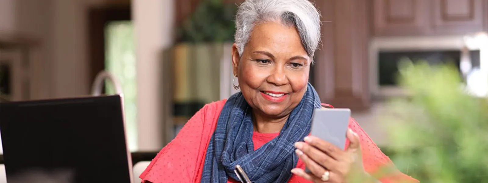 Senior woman using a laptop and phone