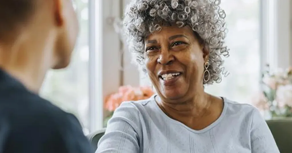 Woman looking at her physician and smiling.