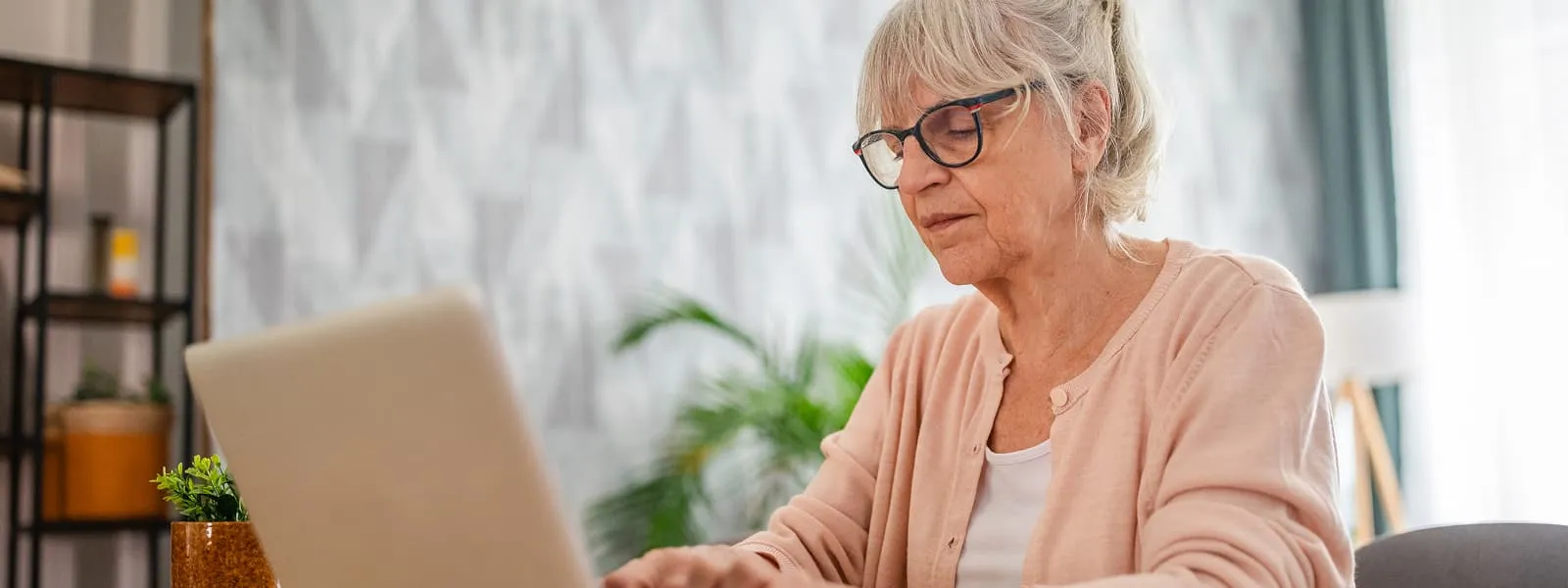 Older couple sitting outside looking at their computer together