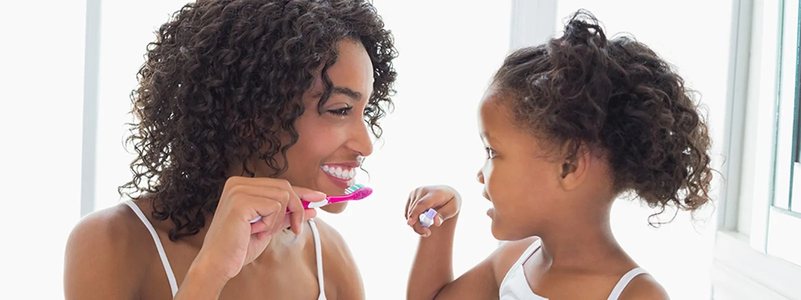 Mother and daughter brushing teeth