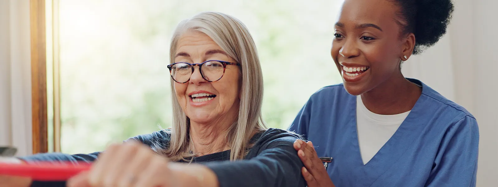 Senior woman being assisted by her physical therapist.