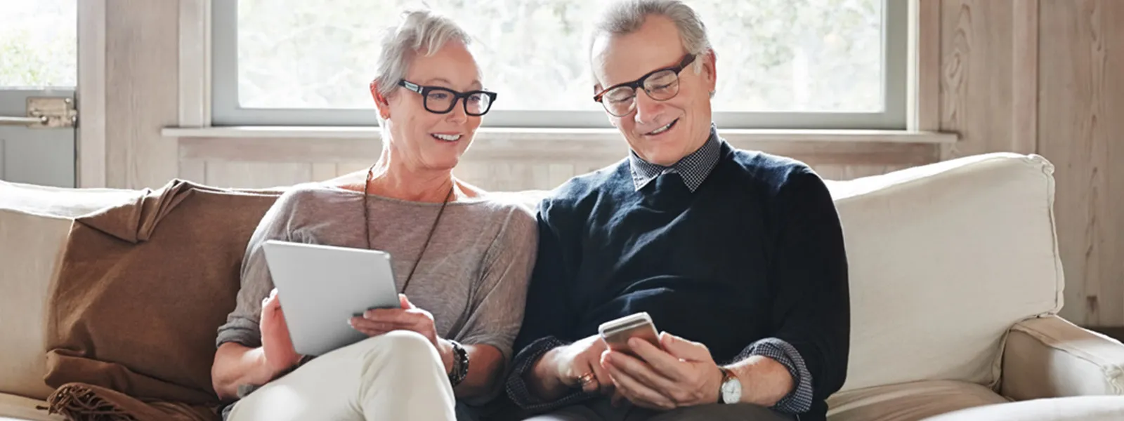 A senior couple reviewing notes while look at a phone.
