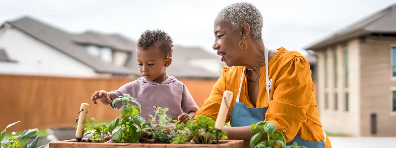 Grandmother working in the garden with grandson