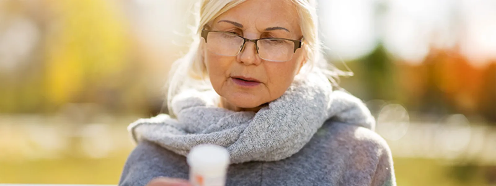woman studying pill bottle