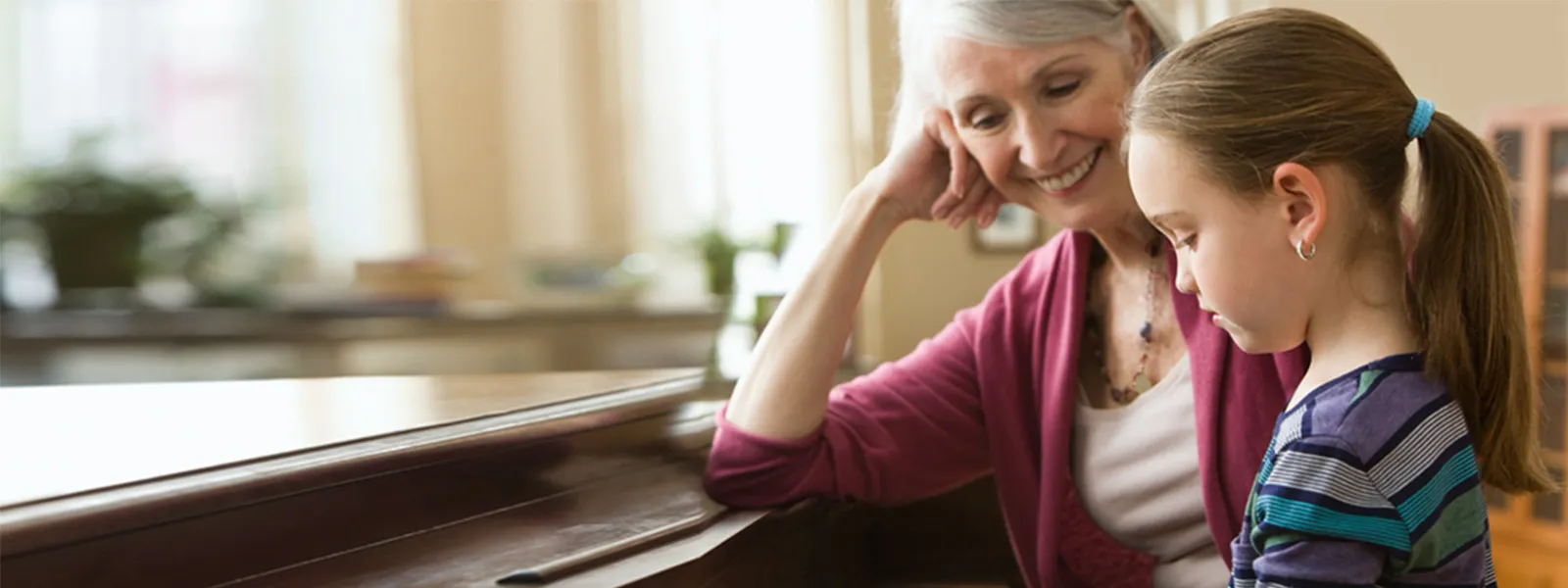 grandmother watching granddaughter on piano