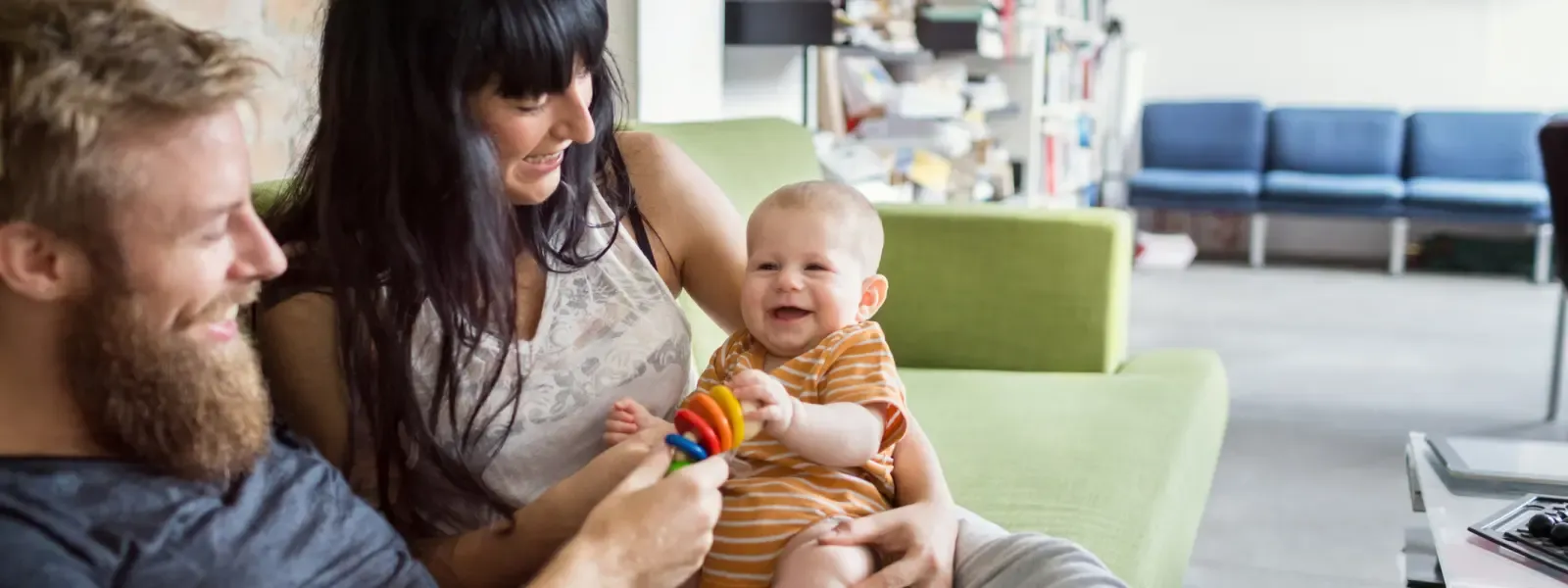 couple playing with their baby on the couch