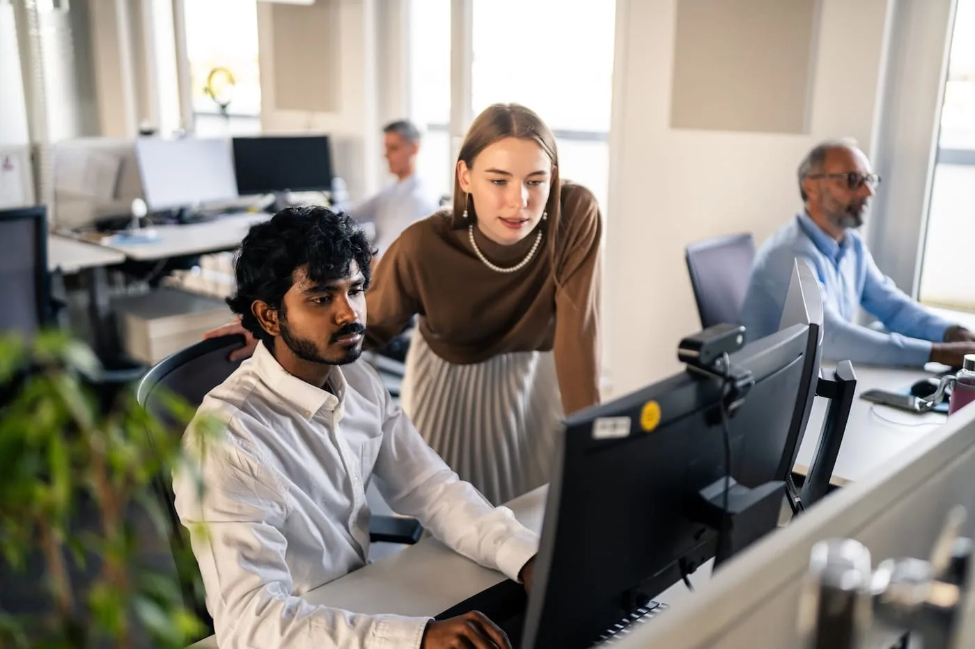 Two colleagues reviewing information together on a laptop