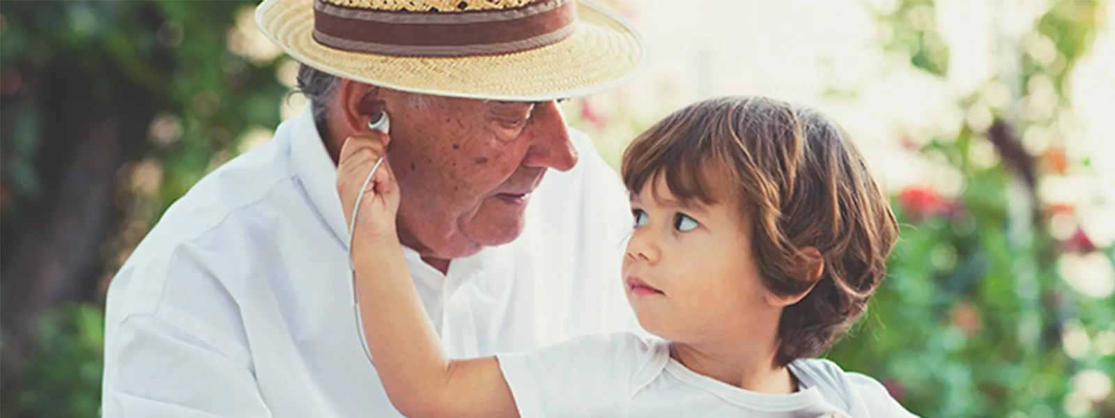 Grandfather and grandson listening to music outside