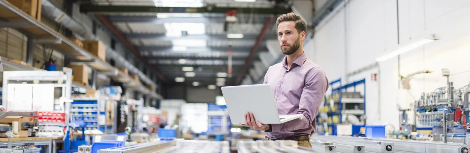 man with laptop in hand in a factory