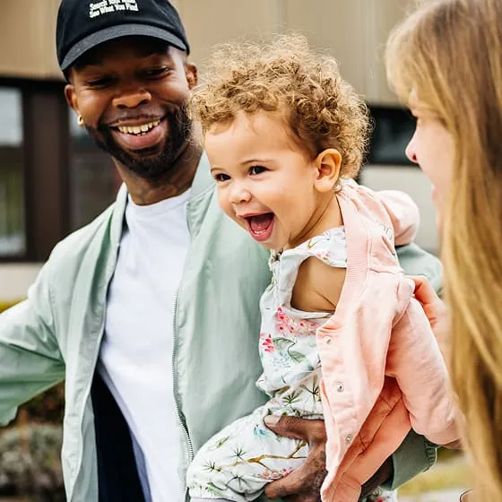 Term life insurance customers, a young family enjoy a walk together. 