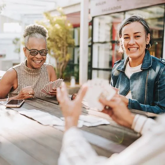Universal life insurance customers, sit together at a table and enjoy a card game. 