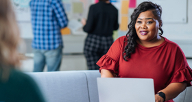 worker working on labtop talking to another coworker