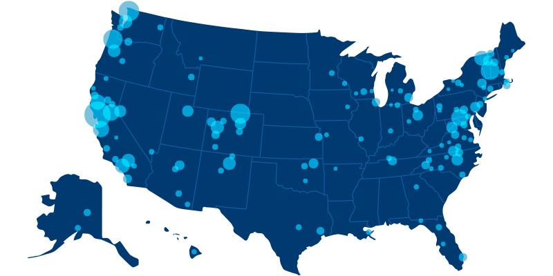 A map of the United States. The map is colored dark blue, with lighter blue lines showing state borders. Various sizes of blue dots on the map indicate where current and future cohousing communities are located.