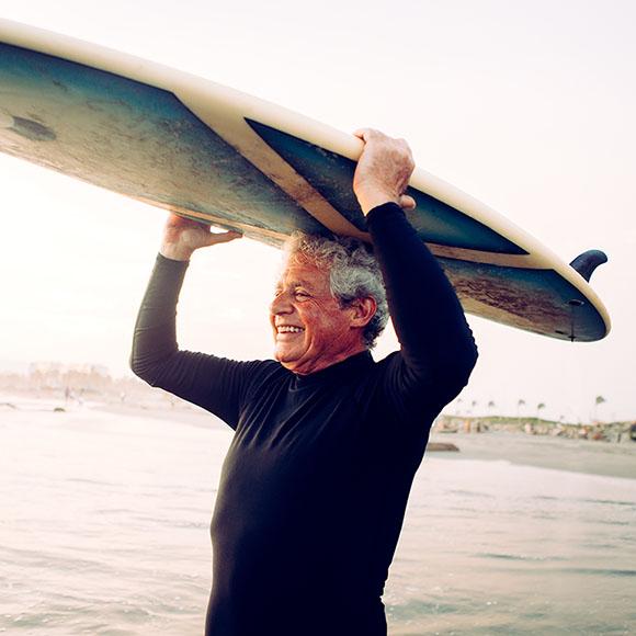Grandfather enjoying coverage from Medicare supplement plan while surfing