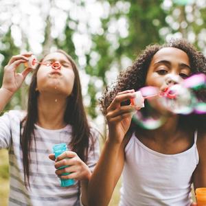 Girl scouts blowing bubbles outside