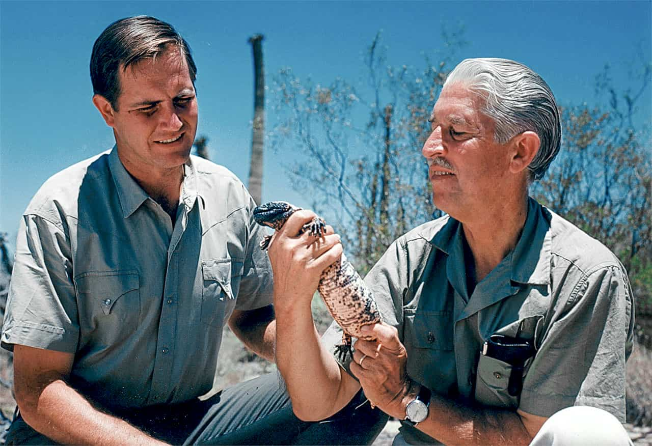 Marlin and Fowler holding a reptile in the desert