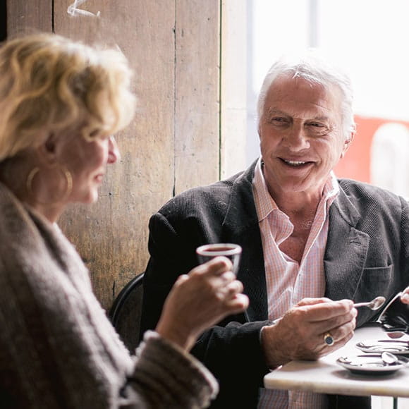 A woman and Man enjoy some coffee at a table