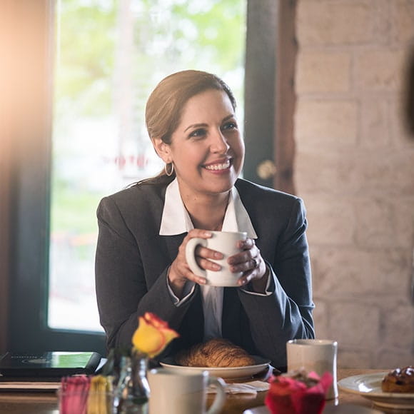 woman at desk with cup of coffee