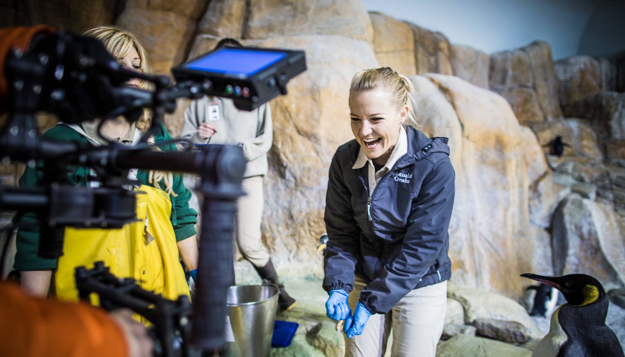 Woman wearing rubber gloves stands in front of a TV camera during the 2013 Wild Guide Contest, part of Wild Kingdom’s 50th anniversary.