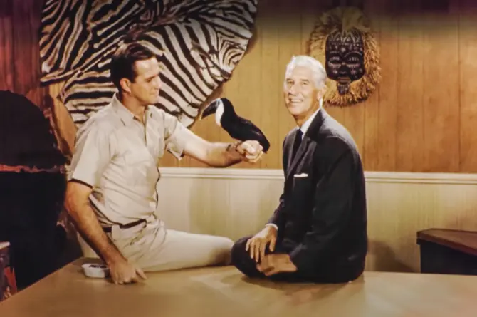 Jim Fowler and Marlin Perkins holding a tropical bird on the original set of Mutual of Omaha's Wild Kingdom.