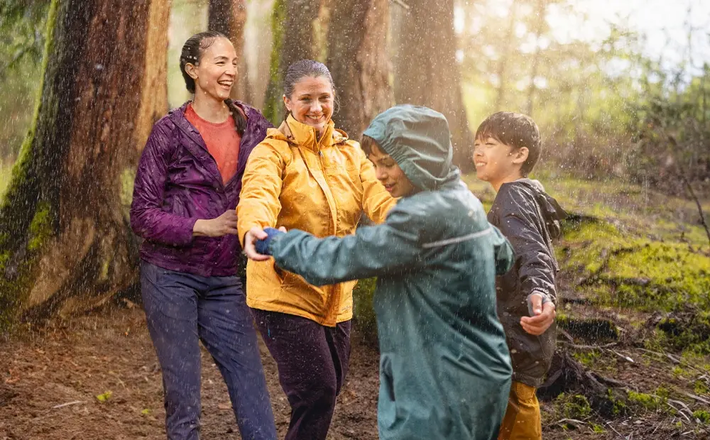 Family laughing in rainy forest