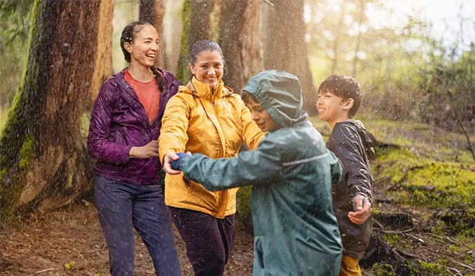 Family laughing in rainy forest